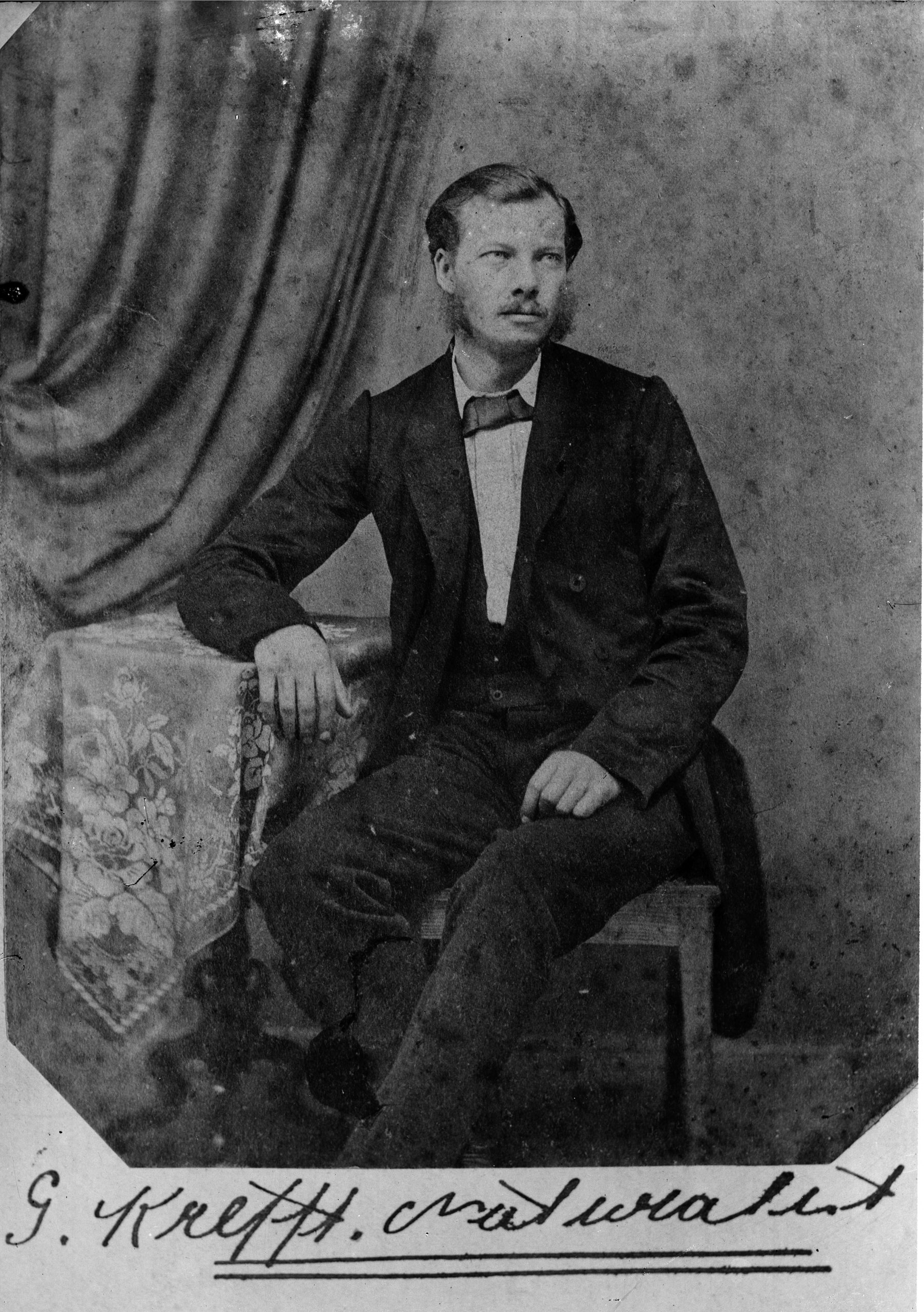 Portrait of a man seated in a suit