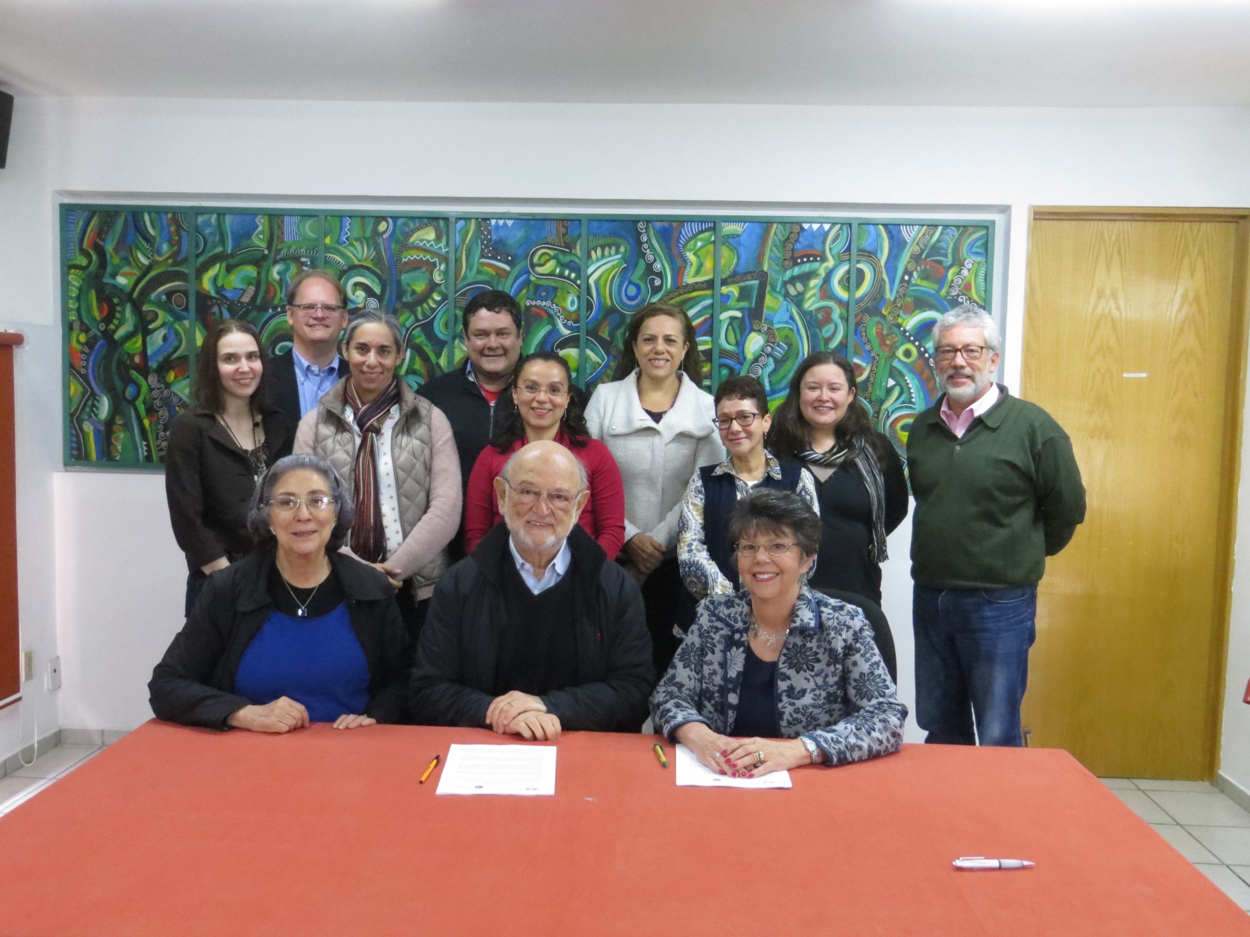 Nancy Gwinn and colleagues pose for a group photo in a conference room after the signing of an MOU