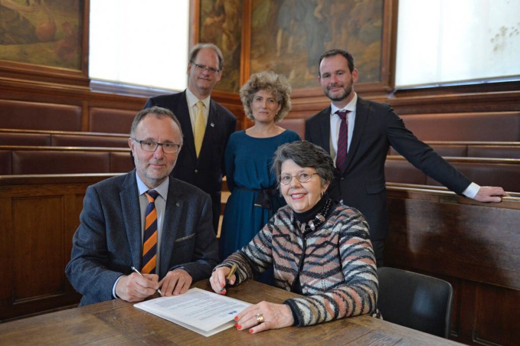 Nancy Gwinn is seated and poised to sign the BHL MOU with colleagues from MNHN Paris