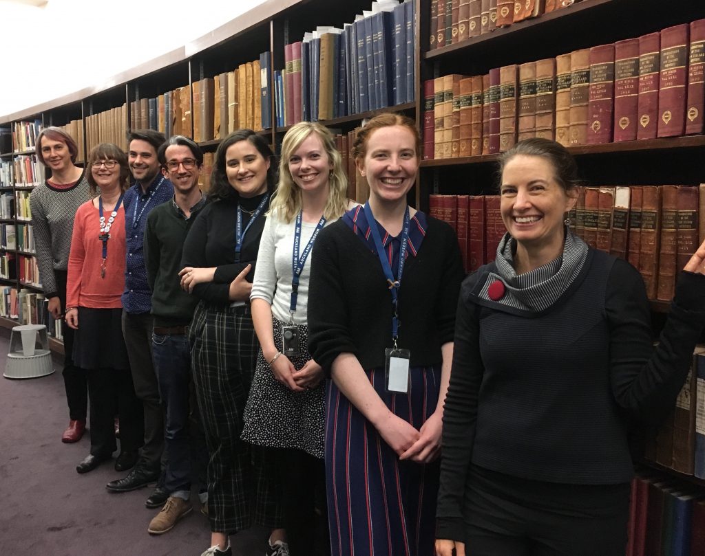 people standing in front of a bookshelf