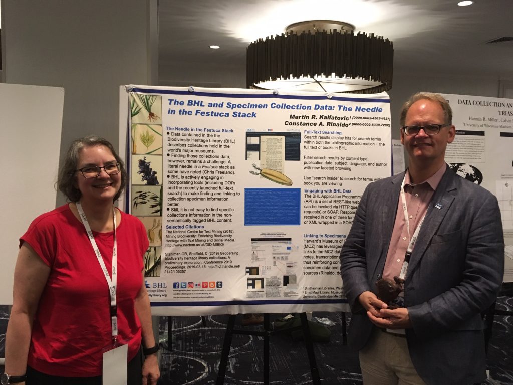 man and woman standing in front of a poster