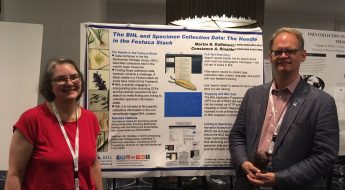 man and woman standing in front of a poster