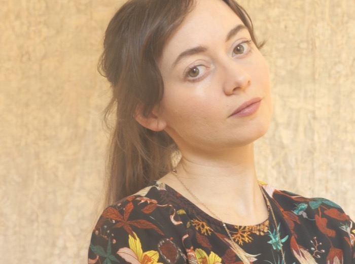 Head shot of a person with long brown hair wearing a floral shirt.