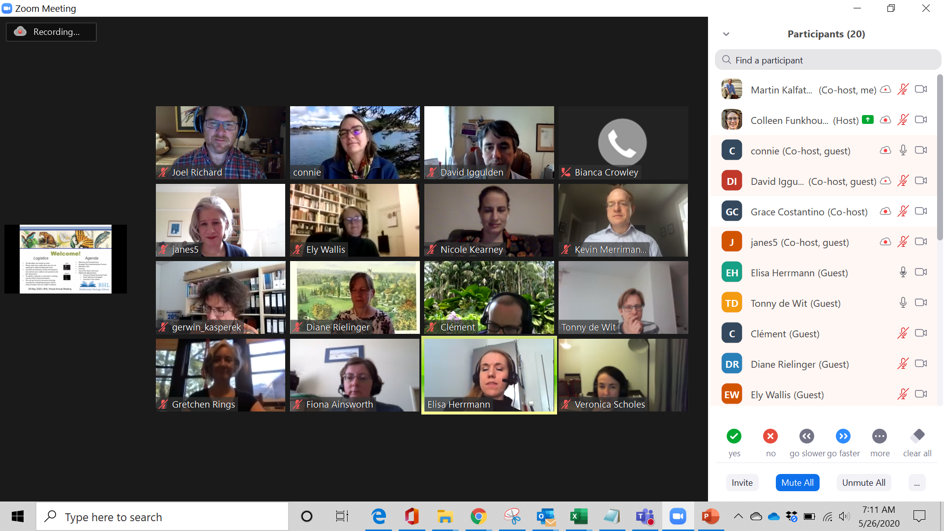 Video conferencing screen showing a grid of people's faces in video screens and a welcome slide