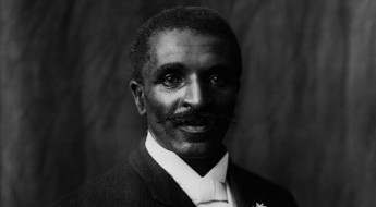 Black and white photograph of a man with short hair and a mustache in a suit