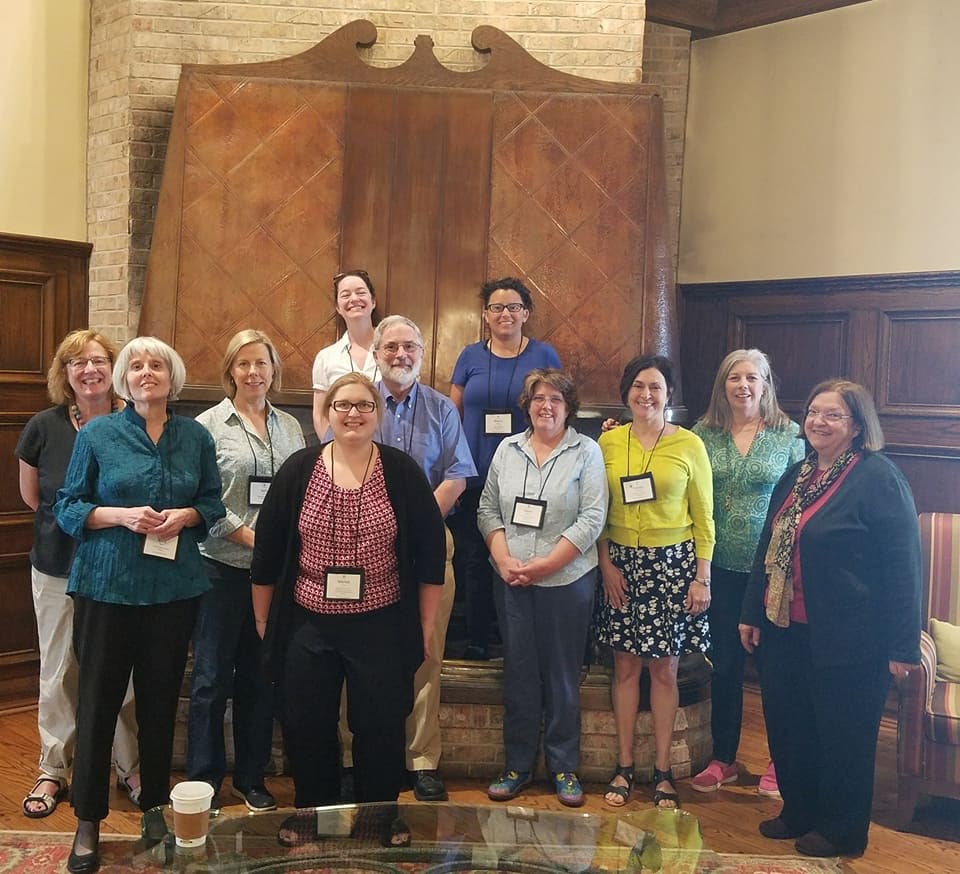 A group of people standing in front of a large wooden display case.