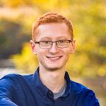 A man with red hair and glasses