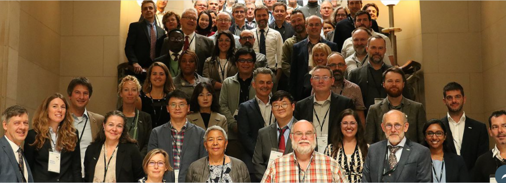 Group photo of meeting attendees assembled on the grand stair case of the Comics Art Museum