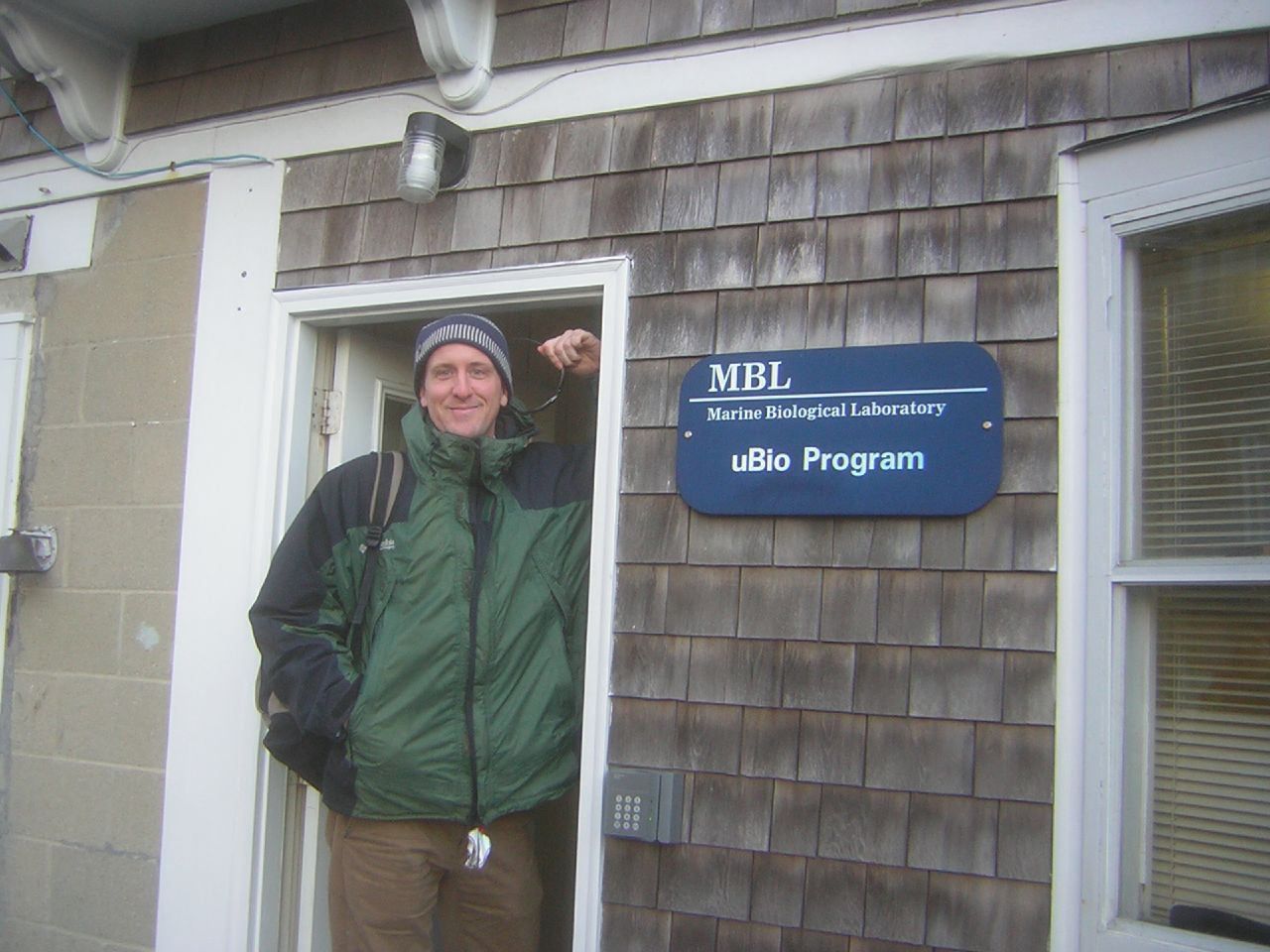 David Remsen smiles next to a sign for the Marine Biological Laboratory uBio Program