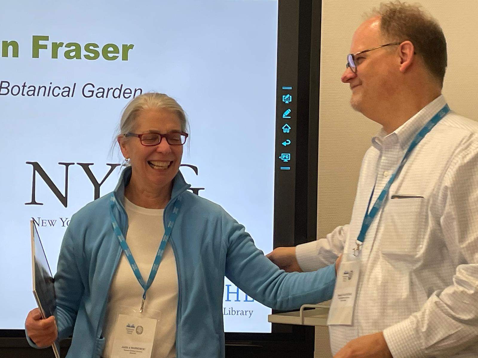 Judy Warnement smiles as she receives a photo book from Martin Kalfatovic