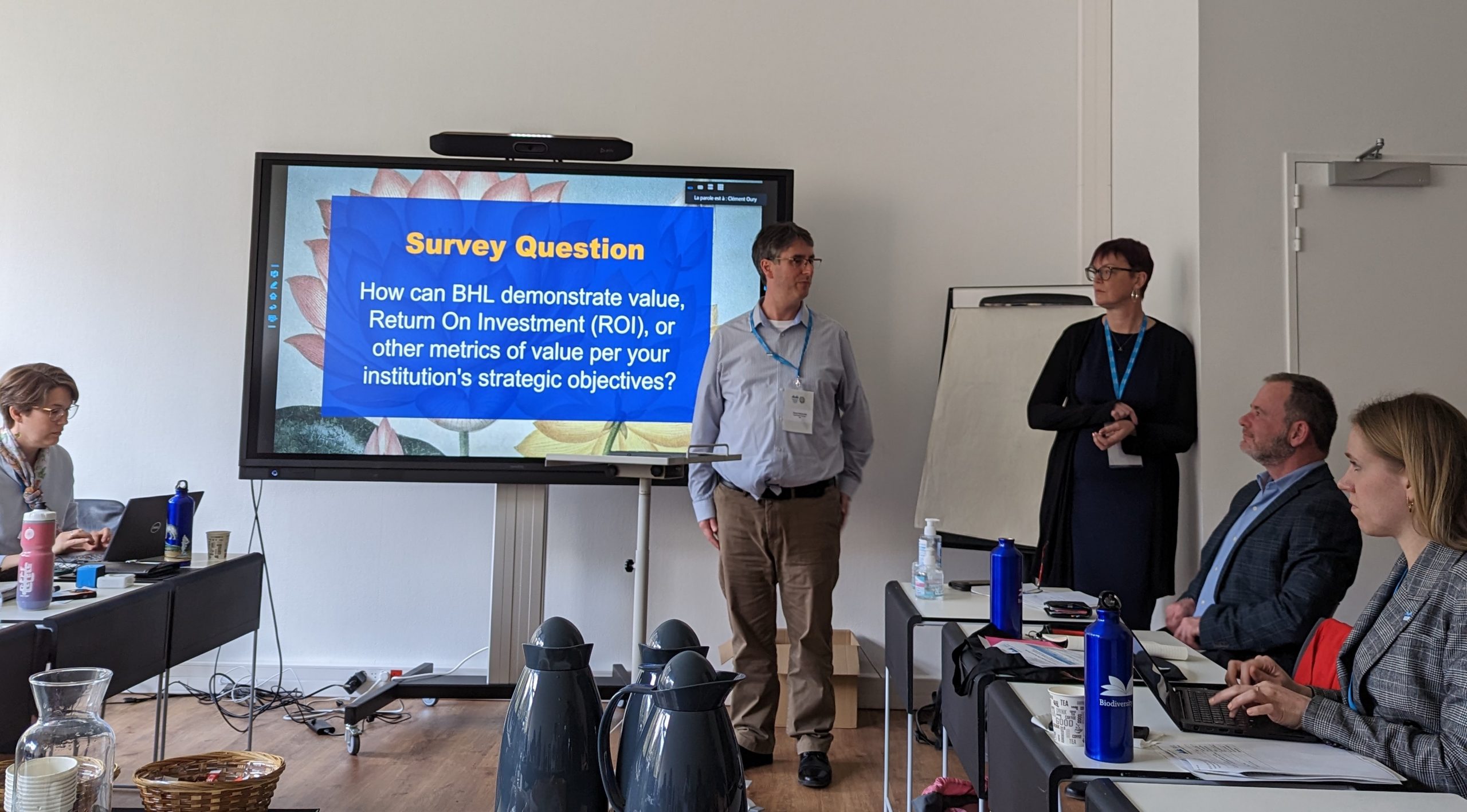 David Iggulden and Kelli Trei stand next to a digital display to present during the BHL annual meeting