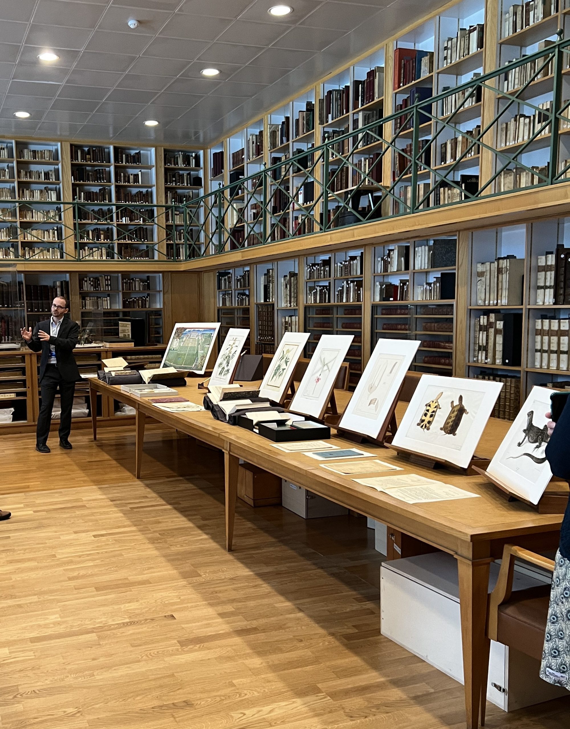 Clement Oury stands in front of a selection of rare books and prints on a large display table in the vellum collection