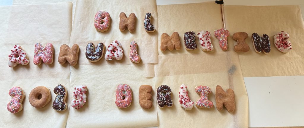 The words "BHL annual meeting 2025 Berlin" is spelled out in donuts covered in various icings and sprinkles