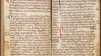 A double page spread of a very old book with yellowed pages and red and brown text.